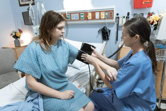 Women is Hospital getting her blood pressure measured.